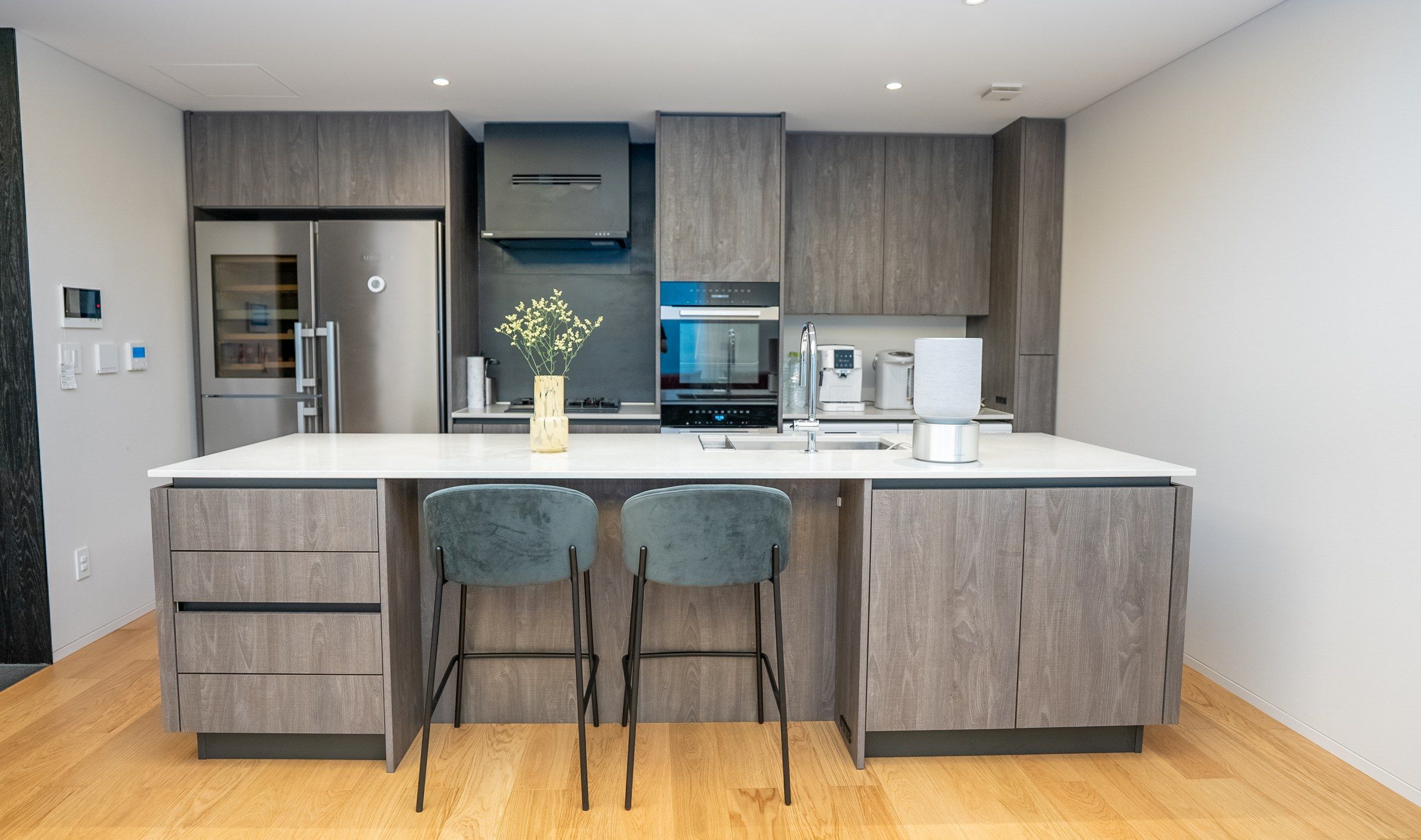 The kitchen island in stone and grey oak.